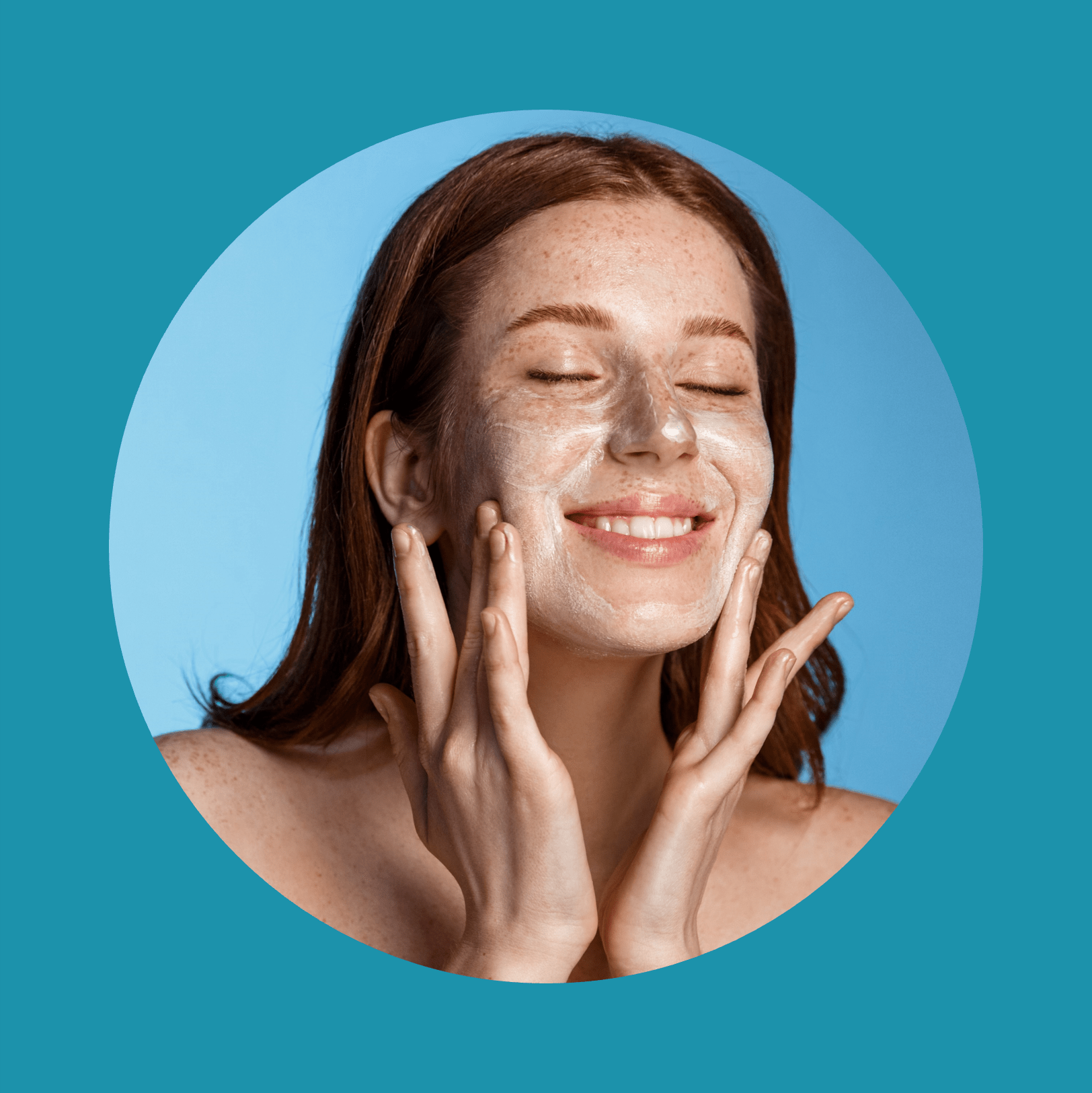Fille rousse souriante avec des taches de rousseur se lavant le visage, utilisant un nettoyant, un gel de soin de la peau après la douche, debout sur fond bleu